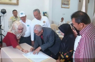SERAHKAN TANAH—Perantau Tanah Datar asal Lintau H.Bustamam meandatangani akta pelepasan hak sertifikat tanah untuk diserahkan kepada Pemkab Tanah Datar, dalam upaya pembangunan rumah sakit di Lintau.(Bakkaba/Wirmas Darwis)